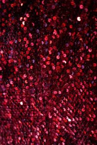 Close-up view of shimmering red sequins on fabric, perfect for fashion backgrounds.